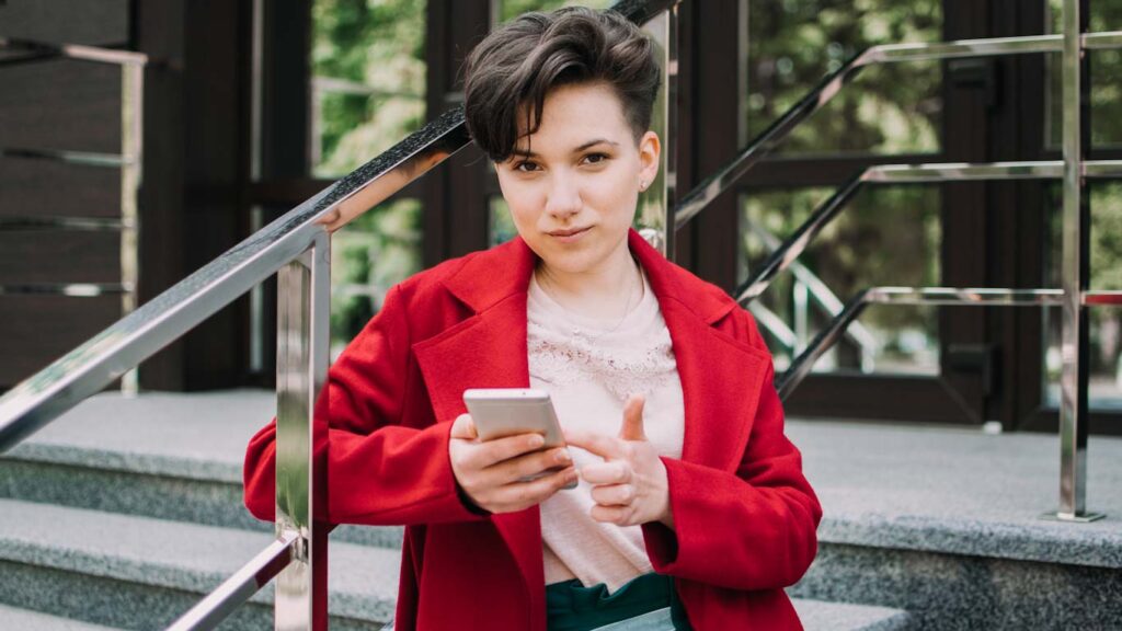 Gen z, micro influencer, technology, youth millennial people concept. Young brunette girl with short hair using mobile phone outdoor.