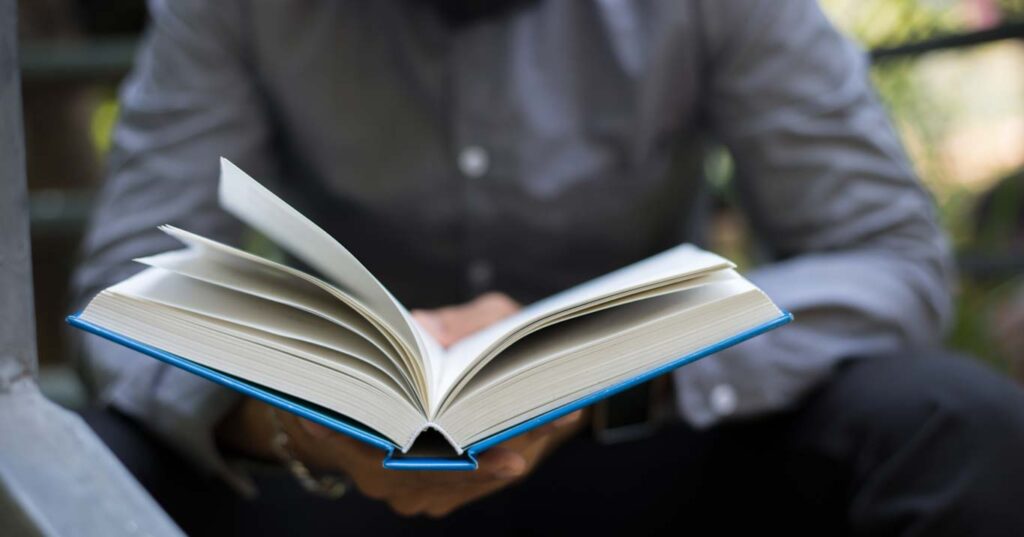 Young hipster beard man reading marketing books in home garden with nature. Education concept.