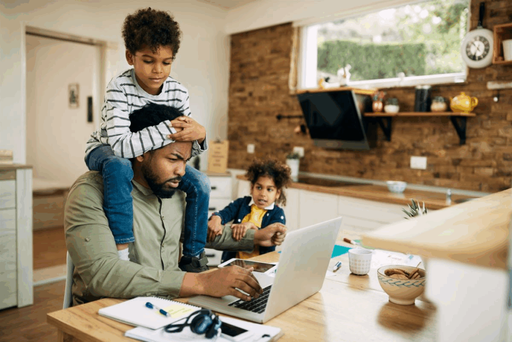 black man working from home while taking care of kids